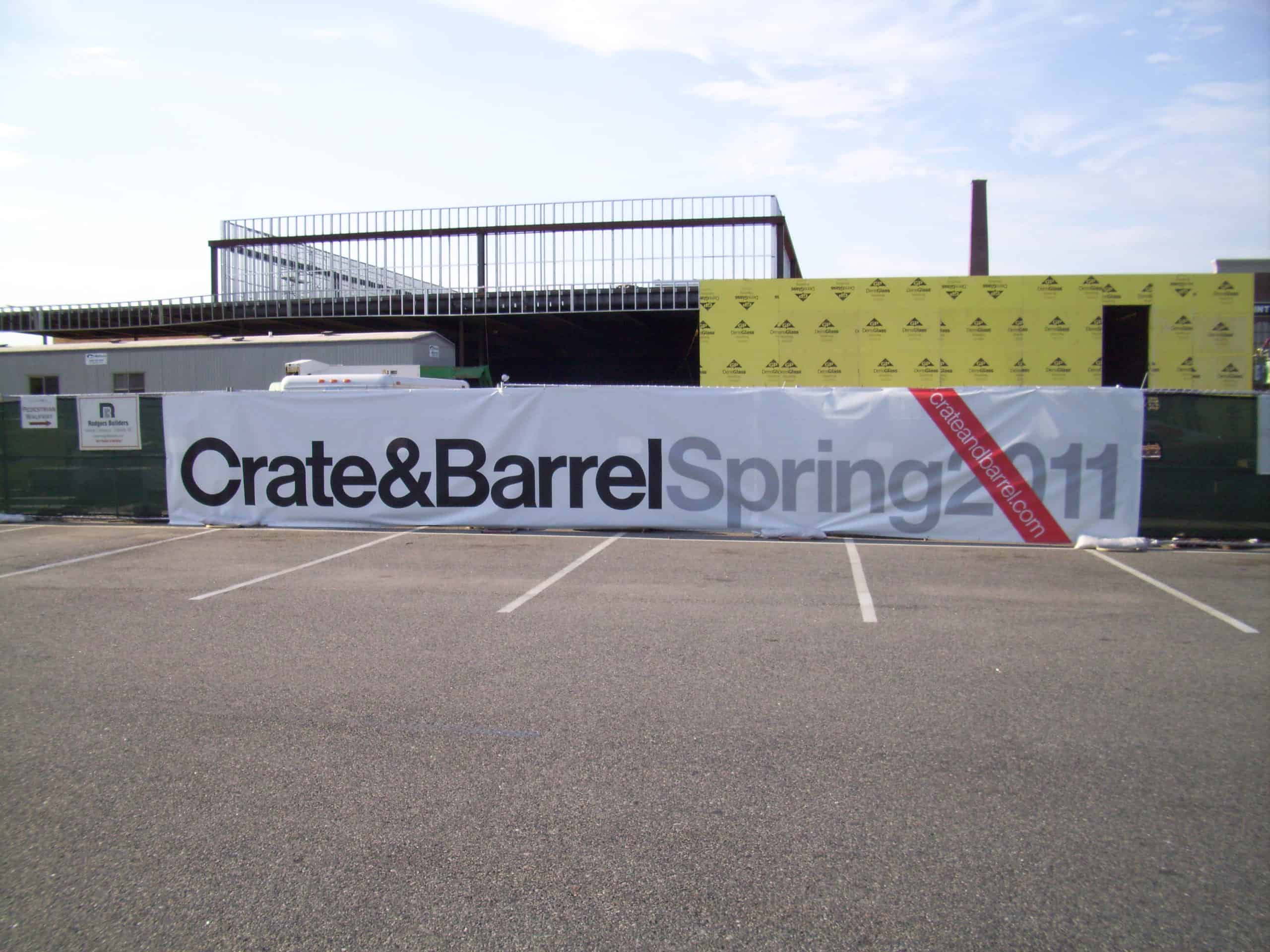 C & B Fence Banner2 a crate and barrel sign in a parking lot.