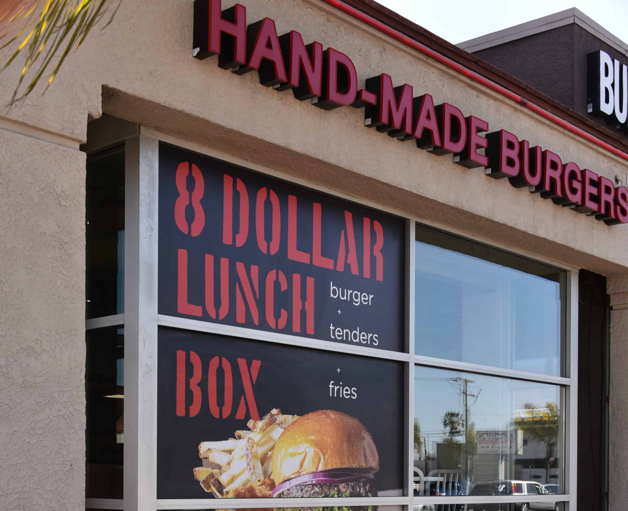 a sign on the front of a restaurant that says 8 dollar lunch box.