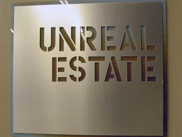 Unreal Estate printing Combination of direct print to acrylic creates a rust background to die cut aluminum for corporate branding.