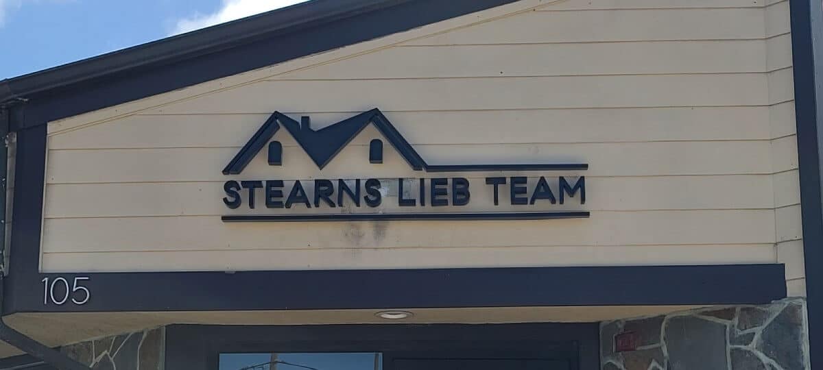 customs signs in los Angeles featuring a white background and blue navy frame in A ceiling shape in front of the one story building  that says steam's lib team. customs signs in los Angeles featuring a white background and blue navy frame in A ceiling shape in front of the one story building that says steam's lib team.