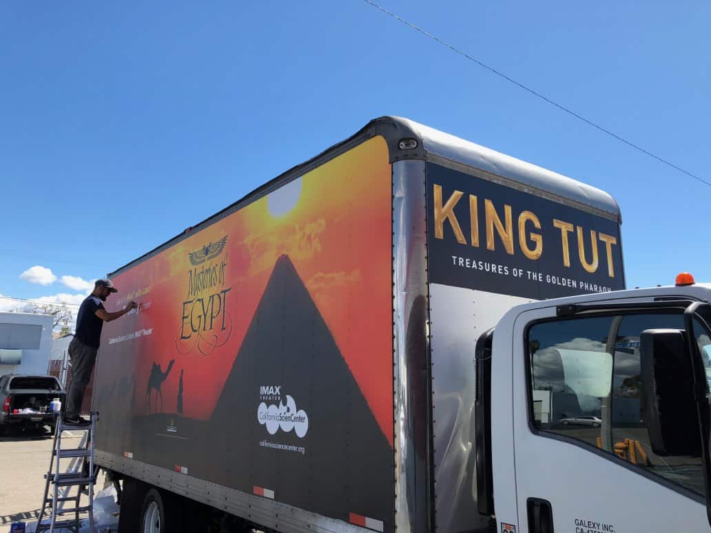 a man standing on the back of a truck.