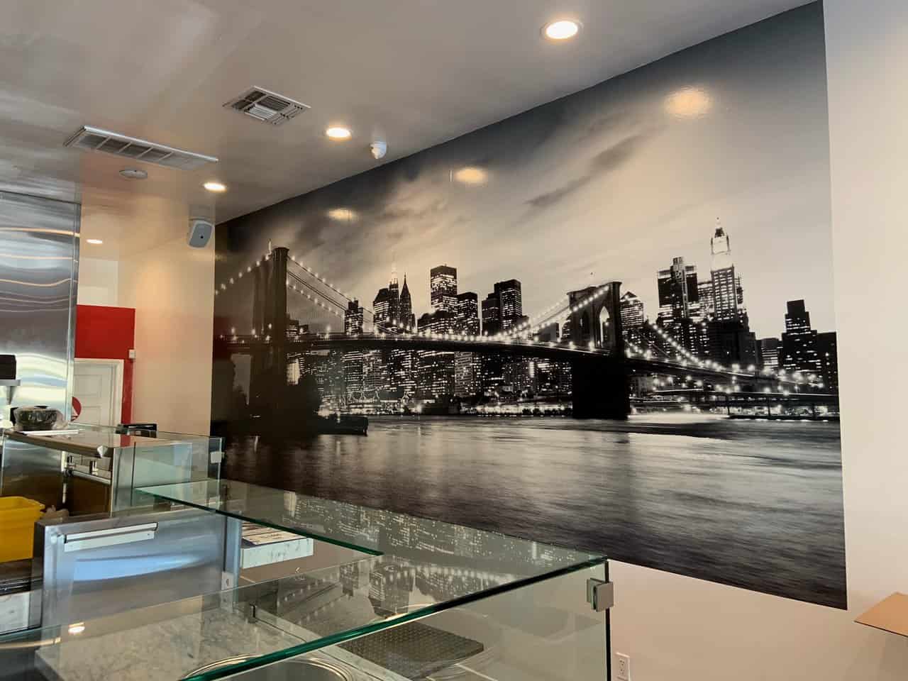 NY Mural a wall with a picture of a city and a bridge.