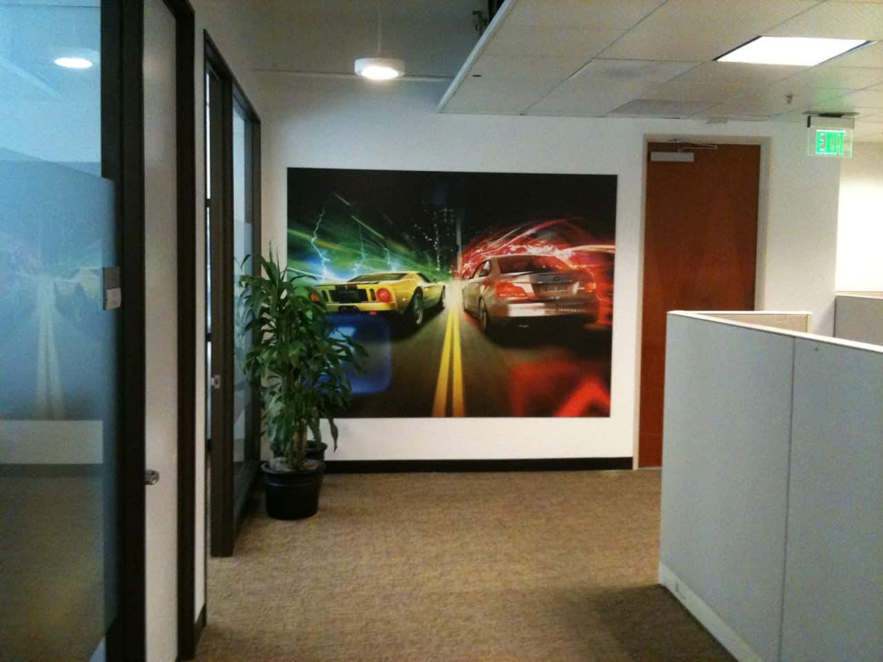 photo_2 an office with a painting of cars on the wall.