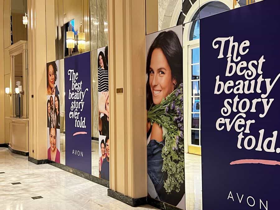 Avon Wrap 5 a row of posters on the wall of a building.