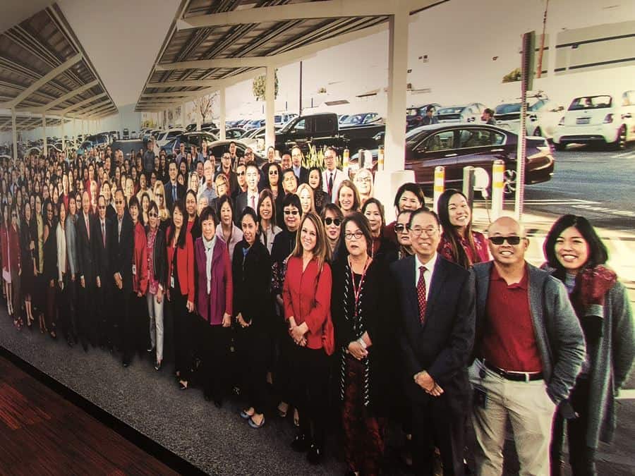 a corporate workspace mural featuring a large group of employees outside the business building posing for a corporate picture a corporate workspace mural featuring a large group of employees outside the business building posing for a corporate picture