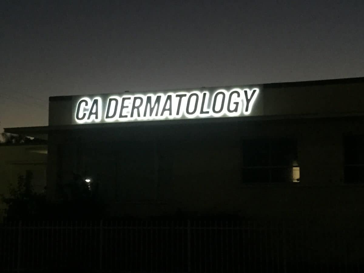 IMG_0655 a building with a neon sign that reads ga dermatology.