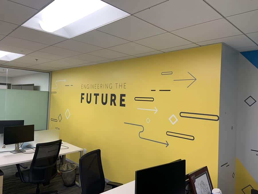 IMG_5354 a corporate office wall mural in a working space featuring "engineering the future" over a yellow background