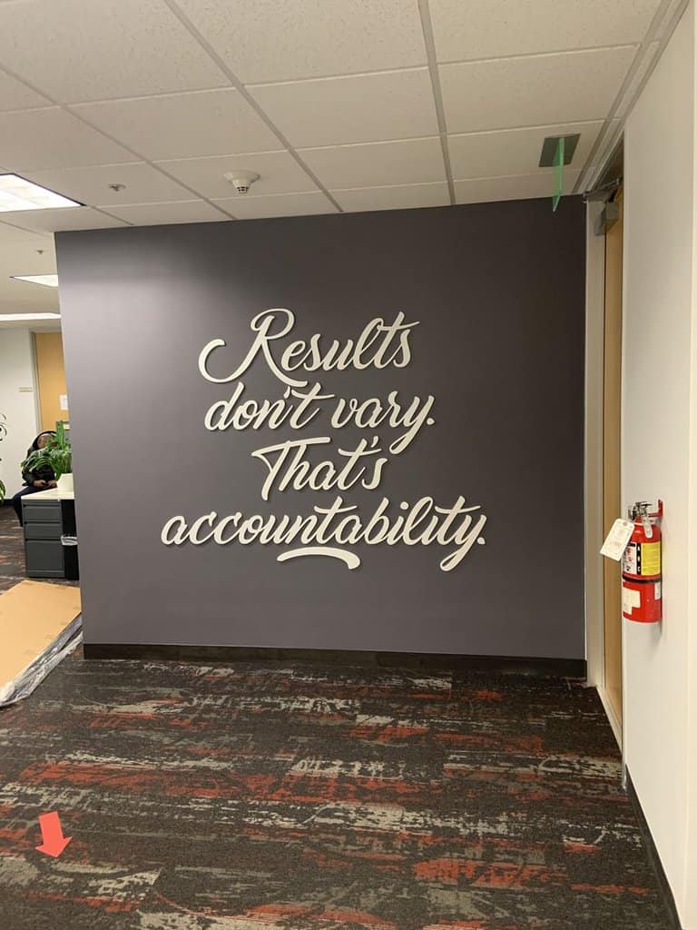 IMG_5358 a business wall mural that reads "results don't vary that's accountability" with white letters over a gray background