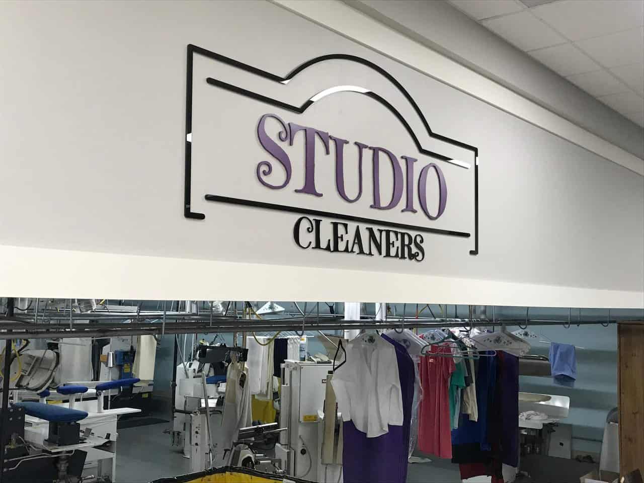 Laser cut Stuido Cleaners a clothing store with a sign that says studio cleaner.