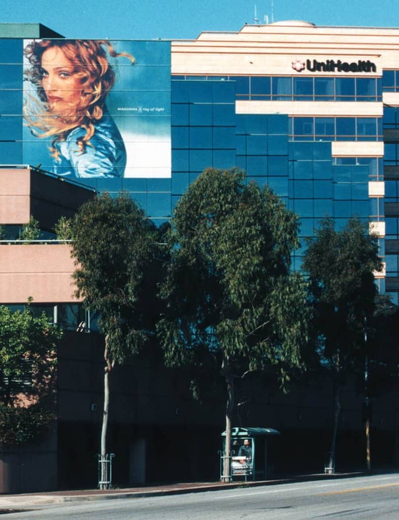 MADONASkew a building with a billboard on the side of it.