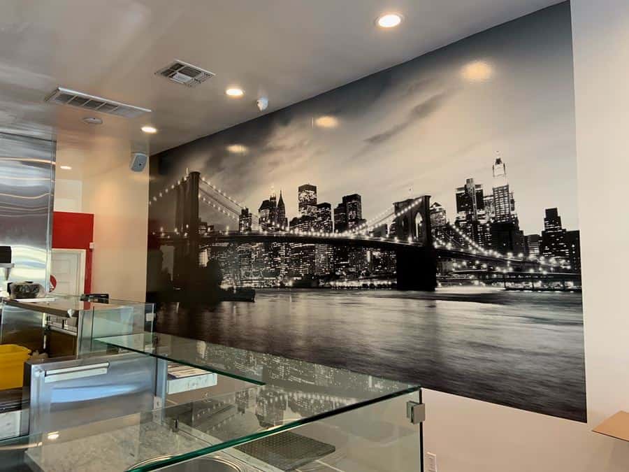 NY Mural a wall with a picture of a city and a bridge.