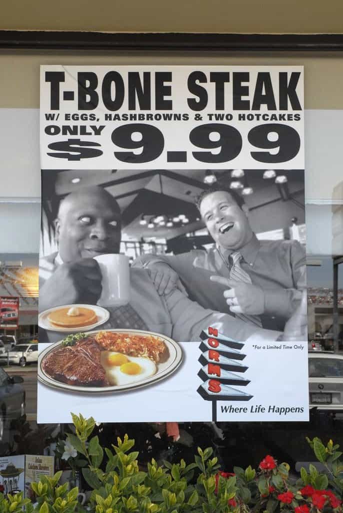 Norms Window a sign advertising a restaurant with a picture of two men.