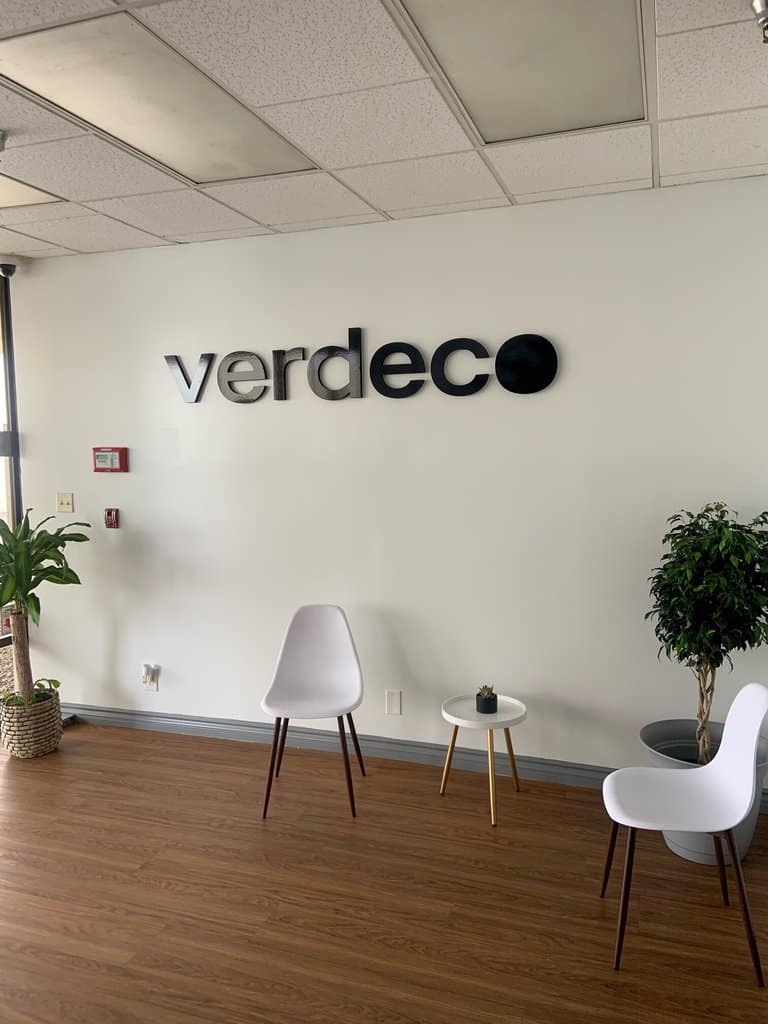 Verdeco a room with chairs and a sign on the wall.