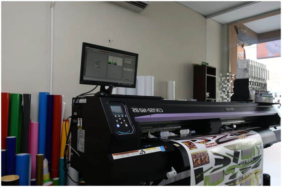 a large printer sitting in front of a computer monitor.
