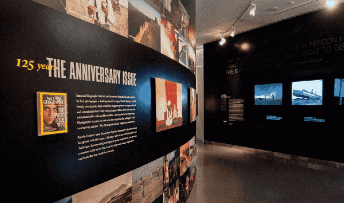 A museum exhibit showcasing a 125th anniversary issue with various informational panels and multimedia displays. brightly lit screens and descriptive texts are visible against dimly lit walls. A museum exhibit showcasing a 125th anniversary issue with various informational panels and multimedia displays. brightly lit screens and descriptive texts are visible against dimly lit walls.