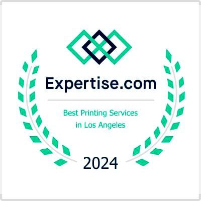 A badge featuring the text "Expertise.com" with two interlocking diamond shapes above it. Below, it reads "Best Printing Services in Los Angeles" and "2024", emphasizing Platon Graphics' excellence. The text is surrounded by a laurel wreath made of green leaves, all set against a white background.